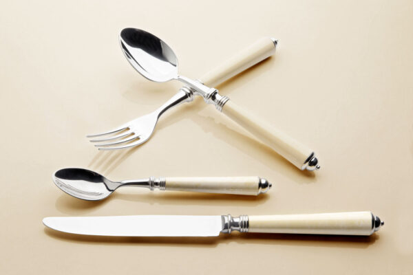 Alain Saint-Joanis Seville Ivory Silver Plated Place Setting on beige surface Alain Saint-Joanis Seville Ivory Silver Plated Place Setting on beige surface