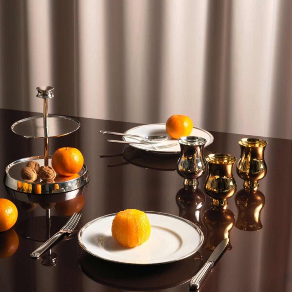 A Table Setting with Puiforcat Cercle d’Orfèvre Porcelain Dinnerware with Normandie Cutlery. Also shown Puiforcat Champagne cups sterling silver and vermeil.