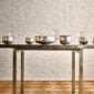 A lifestyle photo of the Puiforcat Selene Collection featuring a gathering of several sterling silver vases and bowls on a dining table.