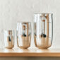 A lifestyle photo of the Puiforcat Selene Collection featuring the 3 sizes of sterling silver vases on a shelf.