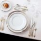 A Table Setting with Puiforcat Cercle d’Orfèvre Porcelain Dinnerware with Elysee Sterling Flatware Gold Accents and Saint-Louis Crystal Wine Glass.