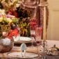 A Table Setting with Puiforcat Cercle d’Orfèvre Porcelain Dinnerware with Deauville Cutlery and Saint-Louis Tommy Champagne Flutes. Ruban Candlestick and Petanque Vase in Silver