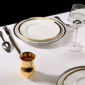 A Table Setting with Puiforcat Cercle d’Orfèvre Porcelain Dinnerware with Elysee Flatware and Saint-Louis Folia Crystal Wine Glass. Also shown, Pour le Champagne Cup in Gold Vermeil.