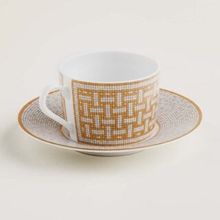 Hermes Mosaique au 24 Gold Tea Cup and Saucer shown on table | Kneen & Co