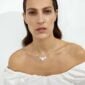 Woman wearing Georg Jensen Daisy Four Flower Necklace in Sterling Silver and White Enamel | Kneen & Co