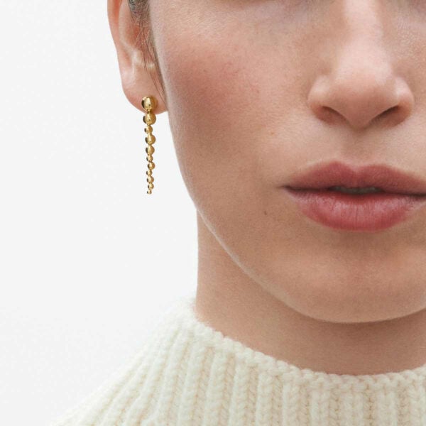 Woman wearing Georg Jensen Moonlight Grapes Long Earrings Gold | Kneen & Co