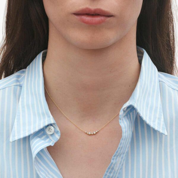Woman wearing George Jensen Signature Diamonds Necklace 0.22 ct in yellow gold | Kneen & Co