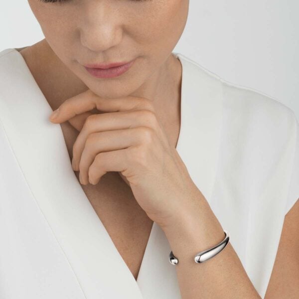 Woman wearing Georg Jensen Mercy Open Bangle in sterling silver | Kneen & Co