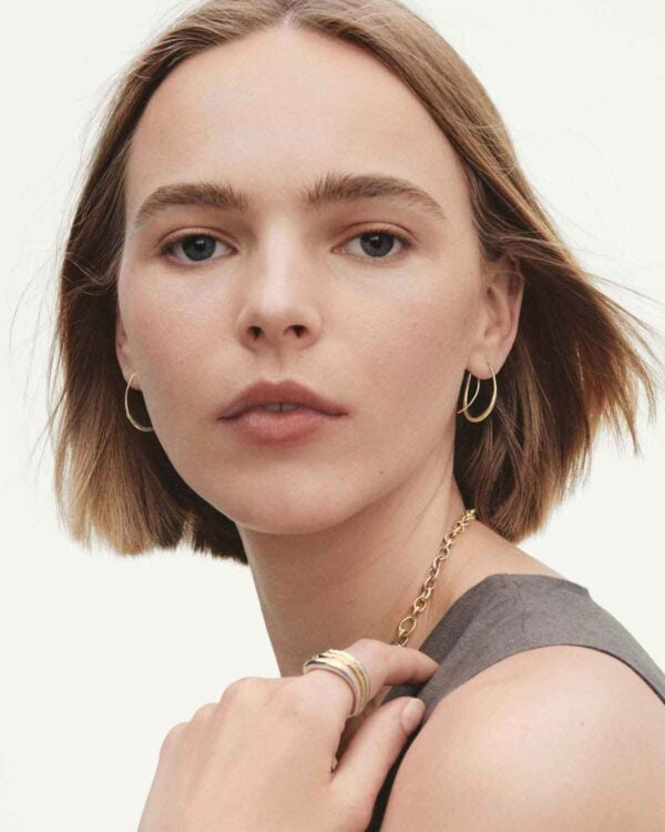 Georg Jensen Offspring Double Earhoops in 18 kt yellow gold on model with rings | Kneen & Co