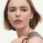 Georg Jensen Offspring Double Earhoops in 18 kt yellow gold on model with rings | Kneen & Co
