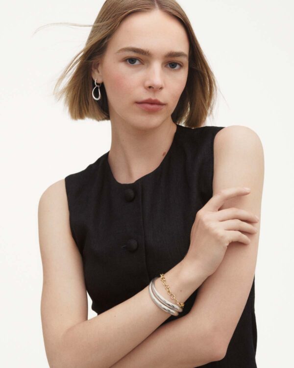 Georg Jensen Offspring Link Bracelet in 18 kt yellow gold on model work with silver bracelet | Kneen & Co