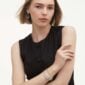 Georg Jensen Offspring Link Bracelet in 18 kt yellow gold on model work with silver bracelet | Kneen & Co