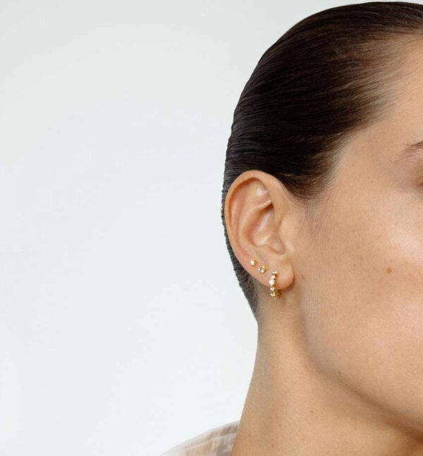 Woman wearing Georg Jensen Signature Diamonds Solitaire Stud Earring 0.20 ct in yellow gold side view| Kneen & Co