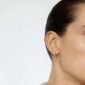 Woman wearing Georg Jensen Signature Diamonds Solitaire Stud Earring 0.20 ct in yellow gold side view| Kneen & Co