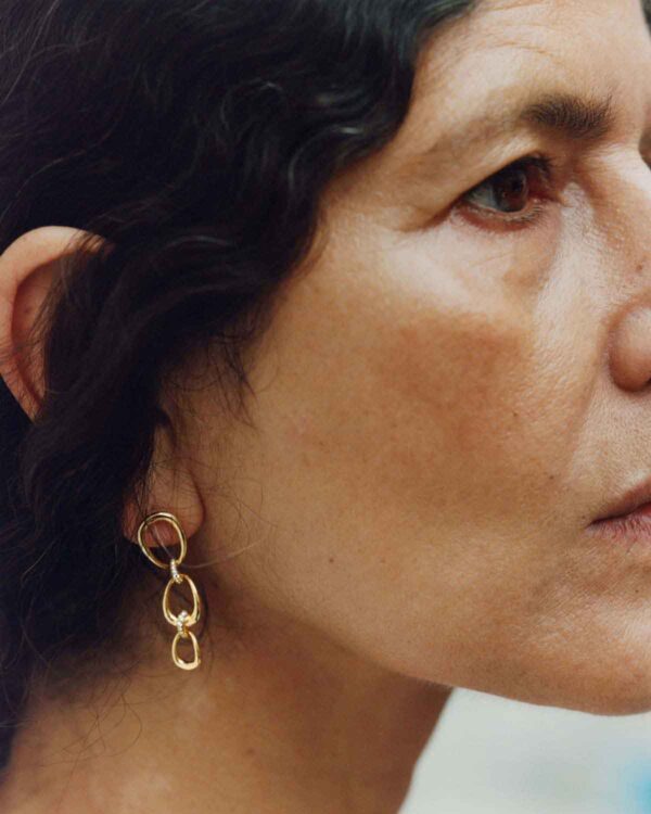 GJ-SS25-BRAND-CAMPAIGN-RABUN-20001753-4X5-1200w-100KB Woman wearing Georg Jensen Offspring Earrings in 18 kt yellow gold | Kneen & Co