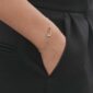 Georg Jensen Offspring Bracelet in sterling silver and 18 kt rose gold close up on model | Kneen & Co