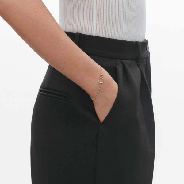 GJ-SS25-ECOM-SHOOT-OFFSPRING-BRACELET-10012371-1200w-100KB Georg Jensen Offspring Bracelet in sterling silver and 18 kt rose gold on model wearing pants | Kneen & Co