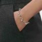 Close up of Woman wearing Georg Jensen Offspring Bracelet in sterling silver | Kneen & Co