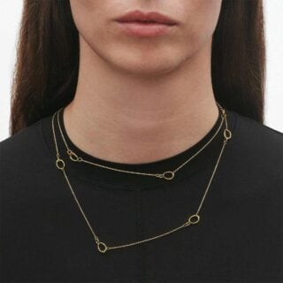 Woman wearing Georg Jensen OFFSPRING Sautoir in 18 kt. yellow gold | Kneen & Co