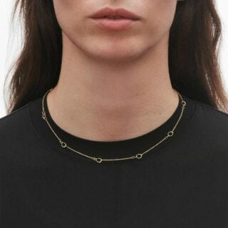 Woman wearing Georg Jensen Offspring Interlinked Necklace, small in 18 kt yellow gold | Kneen & Co