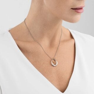 Georg Jensen Offspring Pendant 433B in sterling silver and 18 kt rose gold on model with white shirt | Kneen & Co