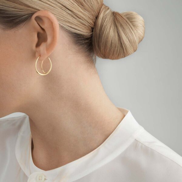 Woman wearing Georg Jensen Offspring Earhoops in sterling silver | Kneen & Co