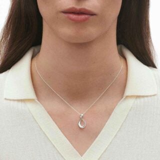 Woman wearing The Georg Jensen Infinity Pendant Necklace in sterling silver | Kneen & Co