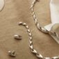 Georg Jensen Reflect Collection Mood image with jewelry laid out on table | Kneen & Co