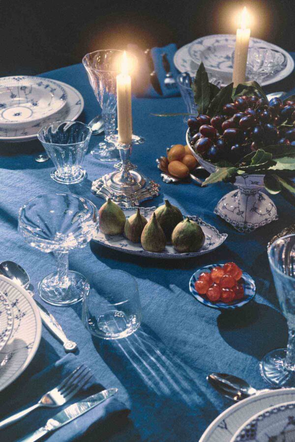 Holiday_2024_BFP_Plate_27cm_BFHL_Bowl_on_High_Foot_80cl_Deep_Plate_21cm_Oval_Dish_24,5cm_Unika_Ivan_Weiss_Bowl_300dpi Royal Copenhagen Blue Fluted Plain dinnerware set on table | Kneen & Co