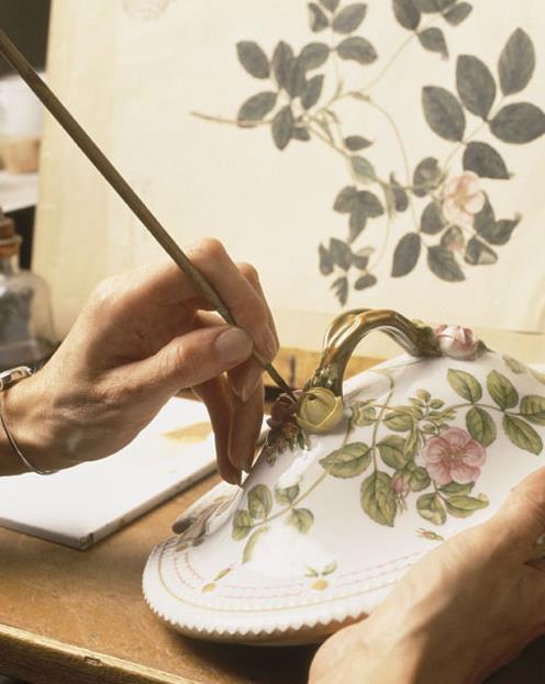 Artisan painting fine green veining on a porcelain leaf in the Royal Copenhagen studio.