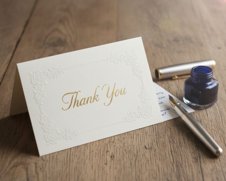 Thank you card on a wooden desk with a fountain pen nearby