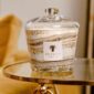 Golden interior setting with Baobab Collection candle in marbled glass with clear dome lid | Kneen & Co