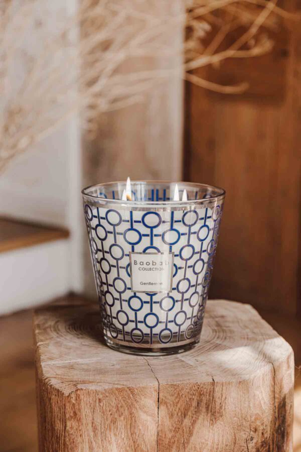 Rustic interior setting with lit Baobab Gentlemen Candle Max 10 in blue and silver graphic glass | Kneen & Co
