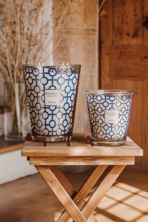 BAOBAB-MAX16GEN-Gentlemen-Lifestyle-2-1200w-100KB Warm domestic setting with two Baobab Gentlemen Candles in blue and silver-rimmed glass | Kneen & Co