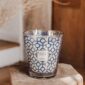 Rustic interior setting with lit Baobab Gentlemen Candle Max 24 in blue and silver graphic glass | Kneen & Co