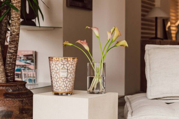 Modern interior setting with lit Baobab Women Candle Max 24 in delicately printed glass with 24-carat yellow gold | Kneen & Co
