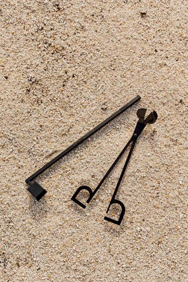 Textured sand environment with Baobab Collection candle snuffer and wick trimmer in black matte metal | Kneen & Co