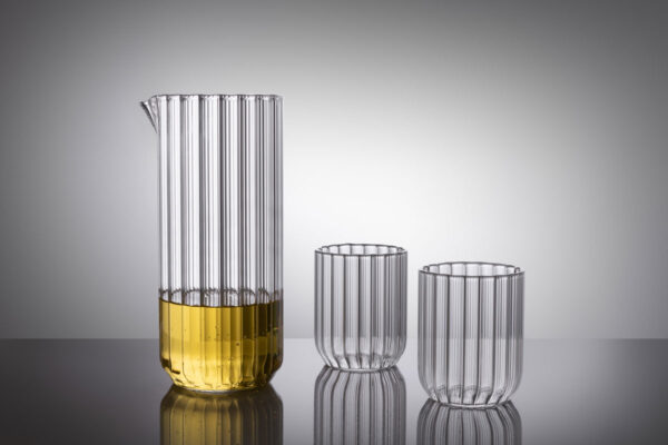 Minimalist studio setting with Fferrone Dearborn Large Carafe and matching glasses in fluted borosilicate glass featuring a clear ribbed texture | Kneen & Co