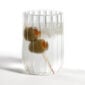 Minimalist white studio background with Fferrone Dearborn Water Glass in fluted borosilicate glass with a clear liquid and olive garnish | Kneen & Co