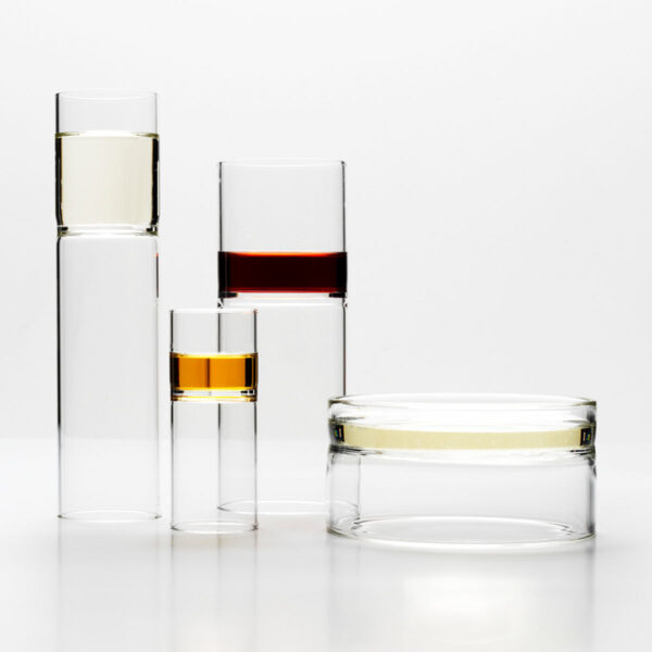Bright minimalist studio setting with Fferrone Revolution Barware in borosilicate glass with amber and clear liquid variants | Kneen & Co