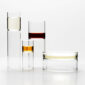 Bright minimalist studio setting with Fferrone Revolution Barware in borosilicate glass with amber and clear liquid variants | Kneen & Co