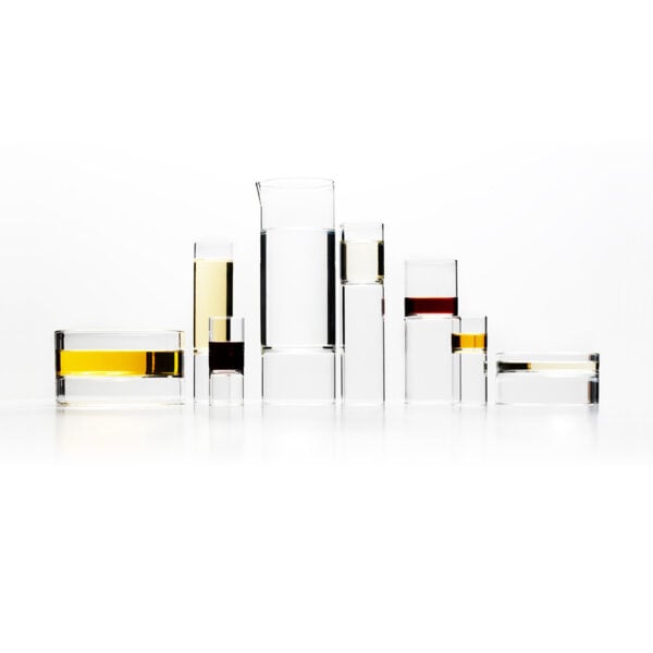 Symmetrical white studio arrangement of Fferrone Revolution Glassware in borosilicate glass with gold and amber liquid variants | Kneen & Co