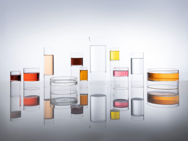 Reflective studio surface with Fferrone Revolution Glassware in borosilicate glass with multi-colored liquid variants | Kneen & Co