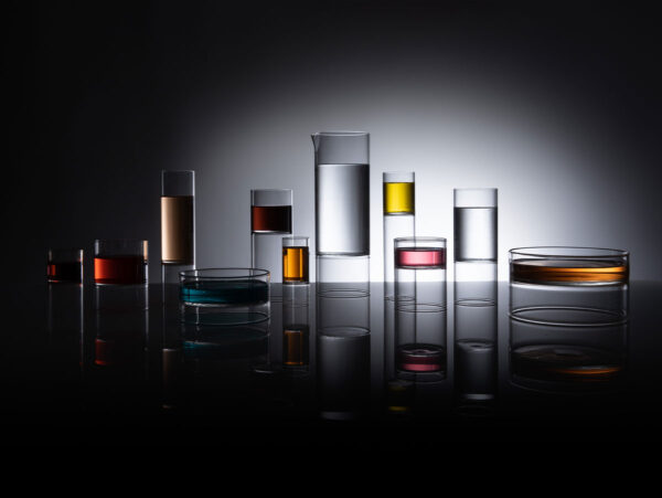 Dark dramatic studio setting with Fferrone Revolution Barware in borosilicate glass with back-lit colored liquid variants | Kneen & Co