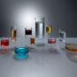 High-angle studio setting with Fferrone Revolution Glassware in borosilicate glass with multi-colored liquid variants on a reflective surface | Kneen & Co