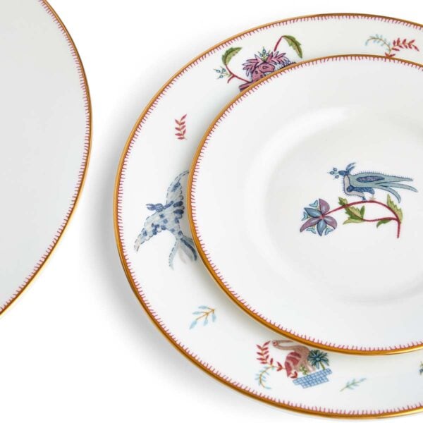 701587253116-Wedgwood-Mythical-Creatures-5-Piece-Place-Setting-BXD-1x27cm-Plate-1x-20cm-Plate-1x15cm-Plate-1xTeacup+Saucer-Leigh-detail2-1200x1200-100KB Close-up studio shot with Wedgwood Kit Kemp Mythical Creatures 5-piece Dinnerware Set in fine bone china featuring whimsical animal illustrations and gold rim detailing | Kneen & Co