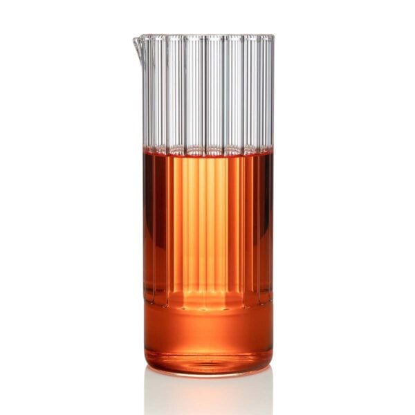 FERRONE-FlightCarafe-190610-FF-0031-1200x1200-100KB Minimalist studio setting with an amber-toned beverage in a Fferrone Flight Carafe made of borosilicate glass featuring a tall fluted cylindrical design | Kneen & Co