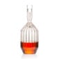 Minimalist studio setting with an amber spirit in a Fferrone Margot Decanter made of borosilicate glass featuring a tall neck and intricate fluted body | Kneen & Co