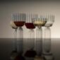 Sophisticated lounge setting with Fferrone Margot Glassware in fluted borosilicate glass featuring an assortment of wine and champagne glasses with colorful liquids and reflections | Kneen & Co