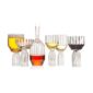 Minimalist studio arrangement of Fferrone Margot Glassware in fluted borosilicate glass featuring an assortment of glasses and a decanter filled with various spirits | Kneen & Co